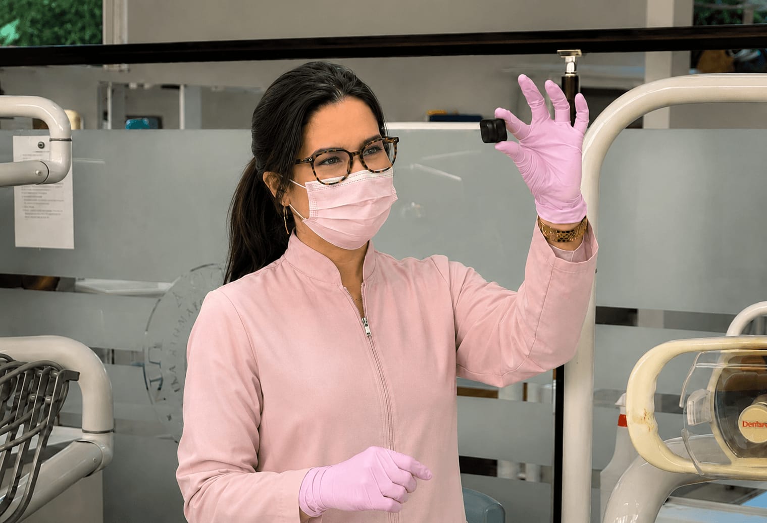Dra Beatriz Matos em atendimento, segurando um sensor de radiografia no consultório